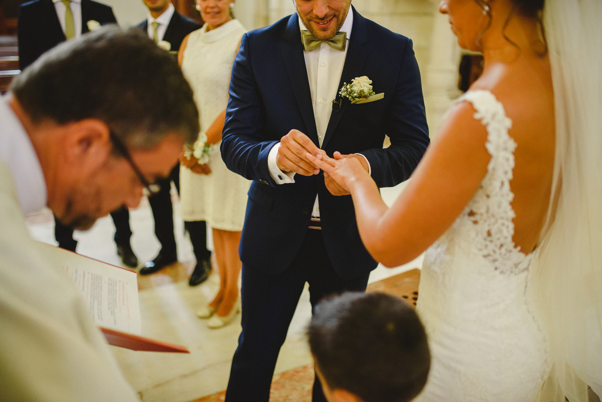 Groom putting wedding ring in bride's finger