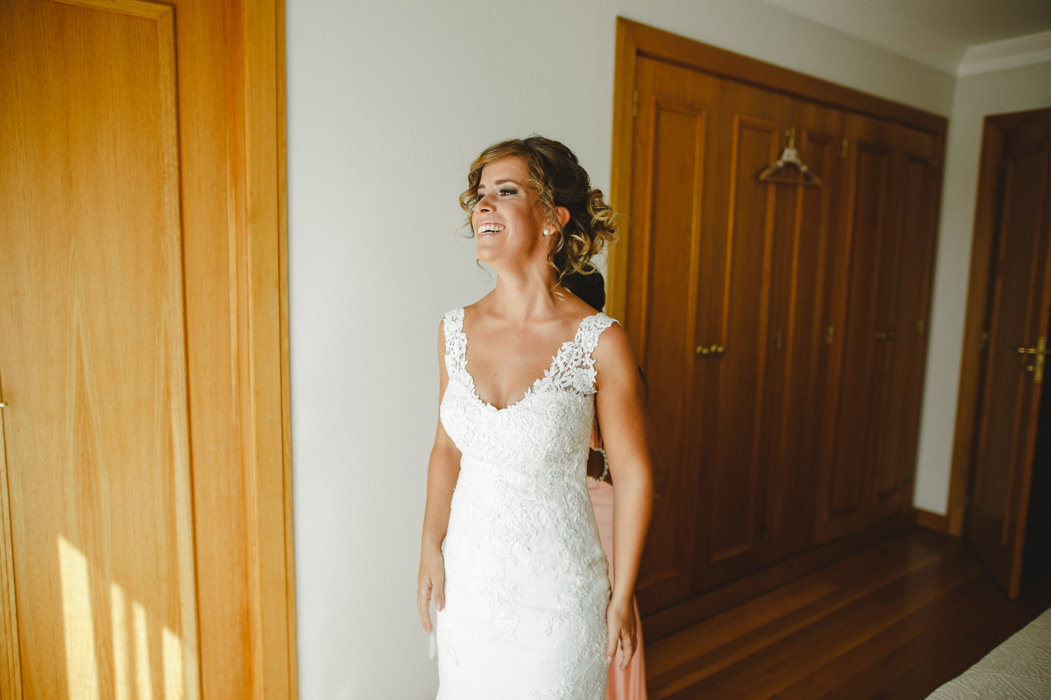 Bride smiling happy after putting on her dress.