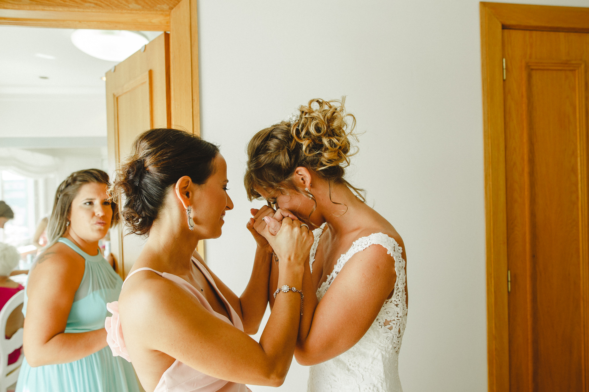 Bride feeling moved holding a friend's hands