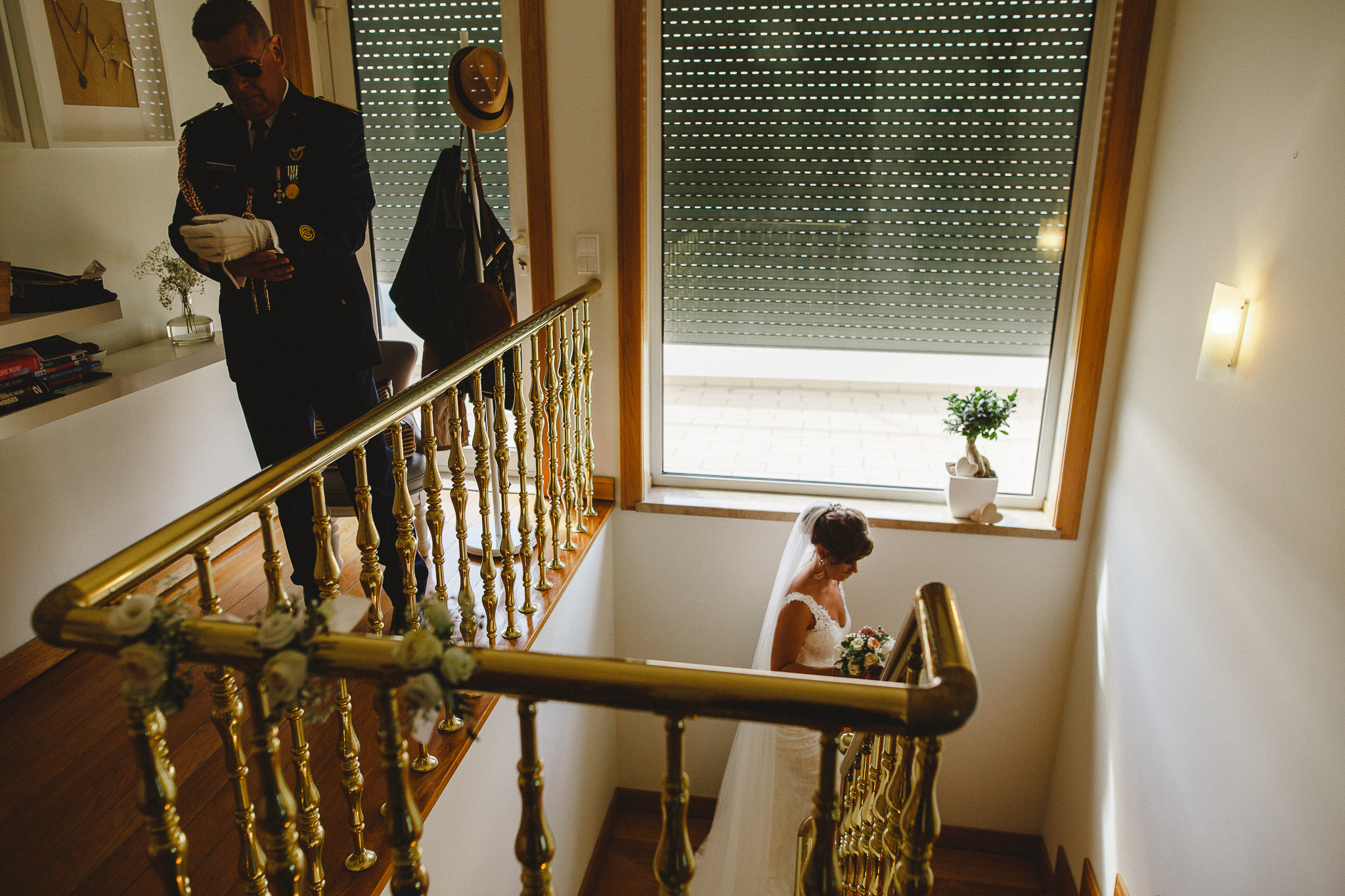 Bride coming upstairs while father of the bride is getting ready to leave the house