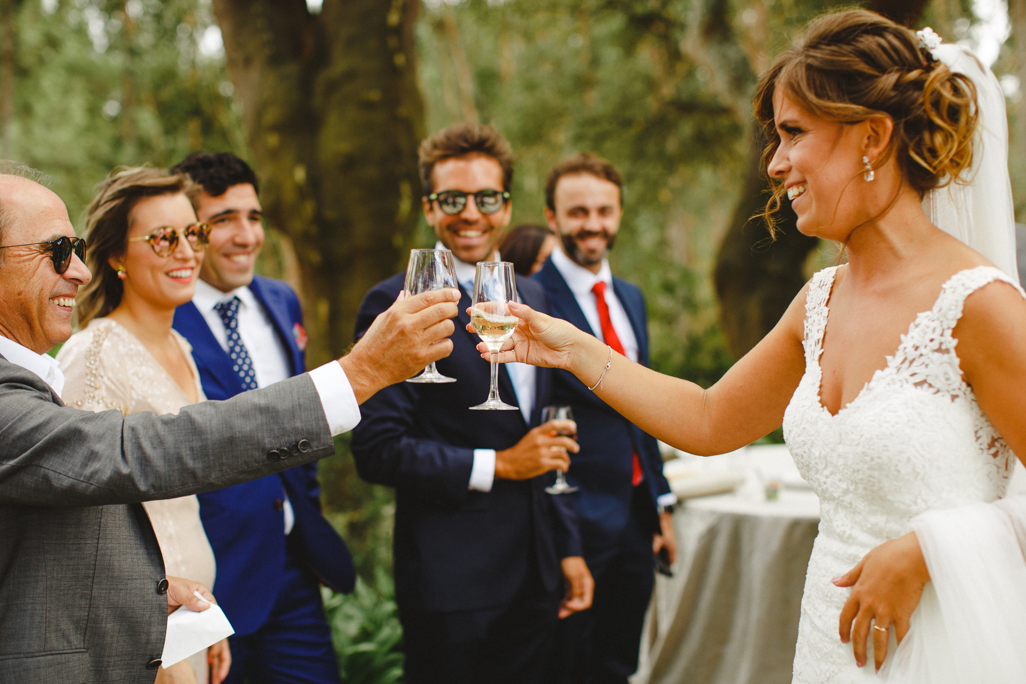 Bride making a toast with friends during cocktail