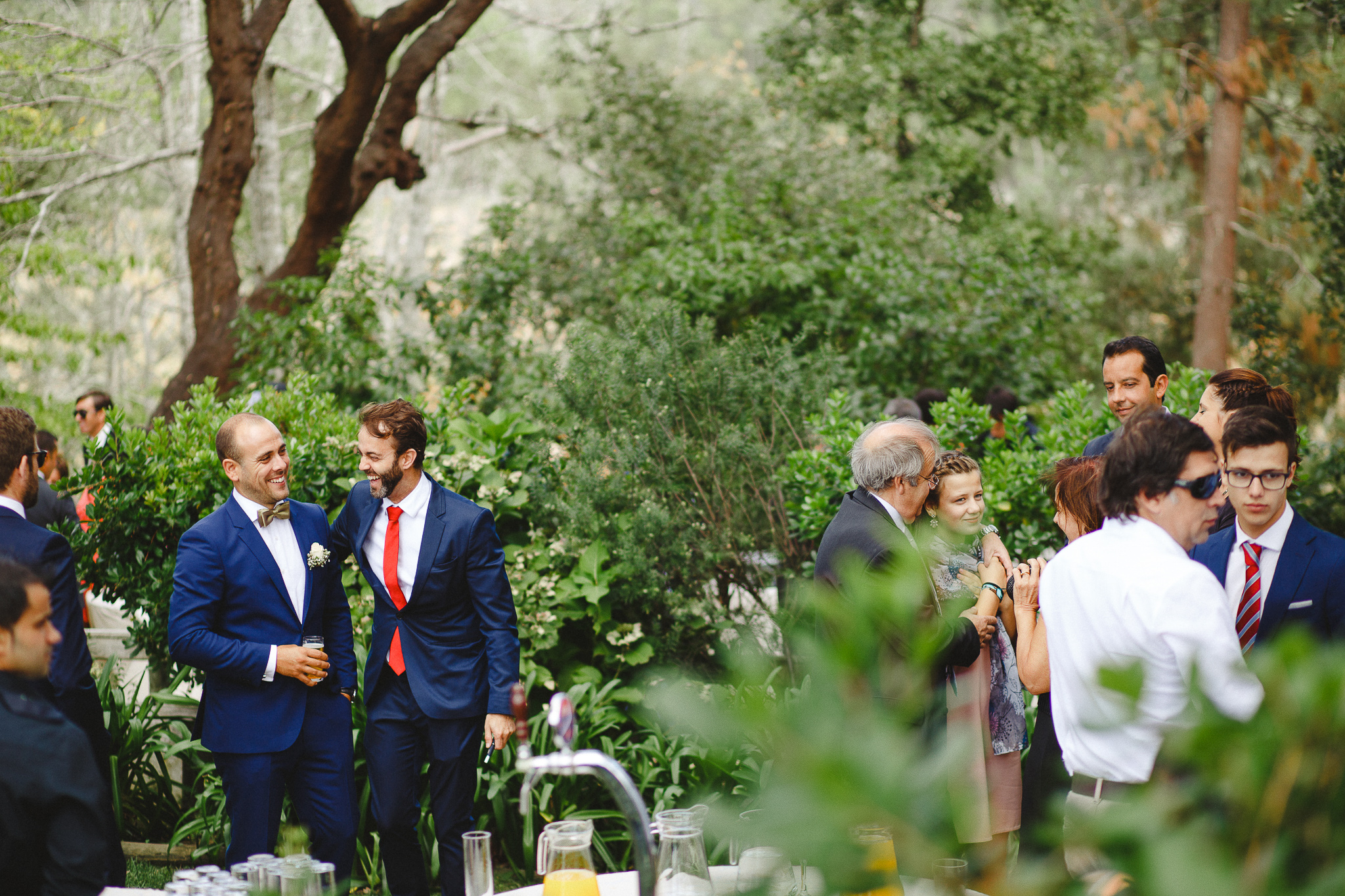 Groom laughing with a friend during cocktail time