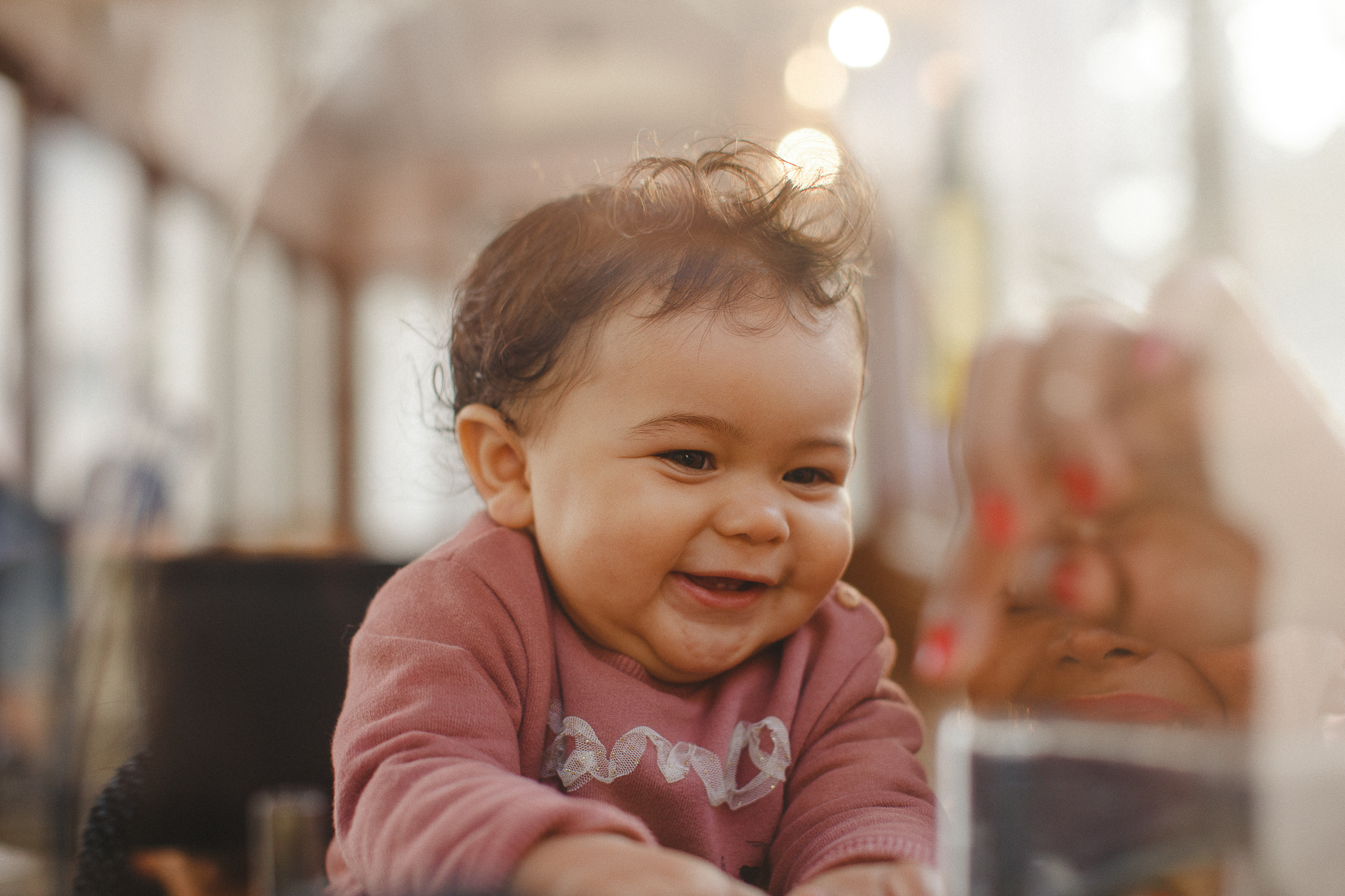 Baby smiling inside of a typical yellow tram in Lisbon, during a family photo shoot. 