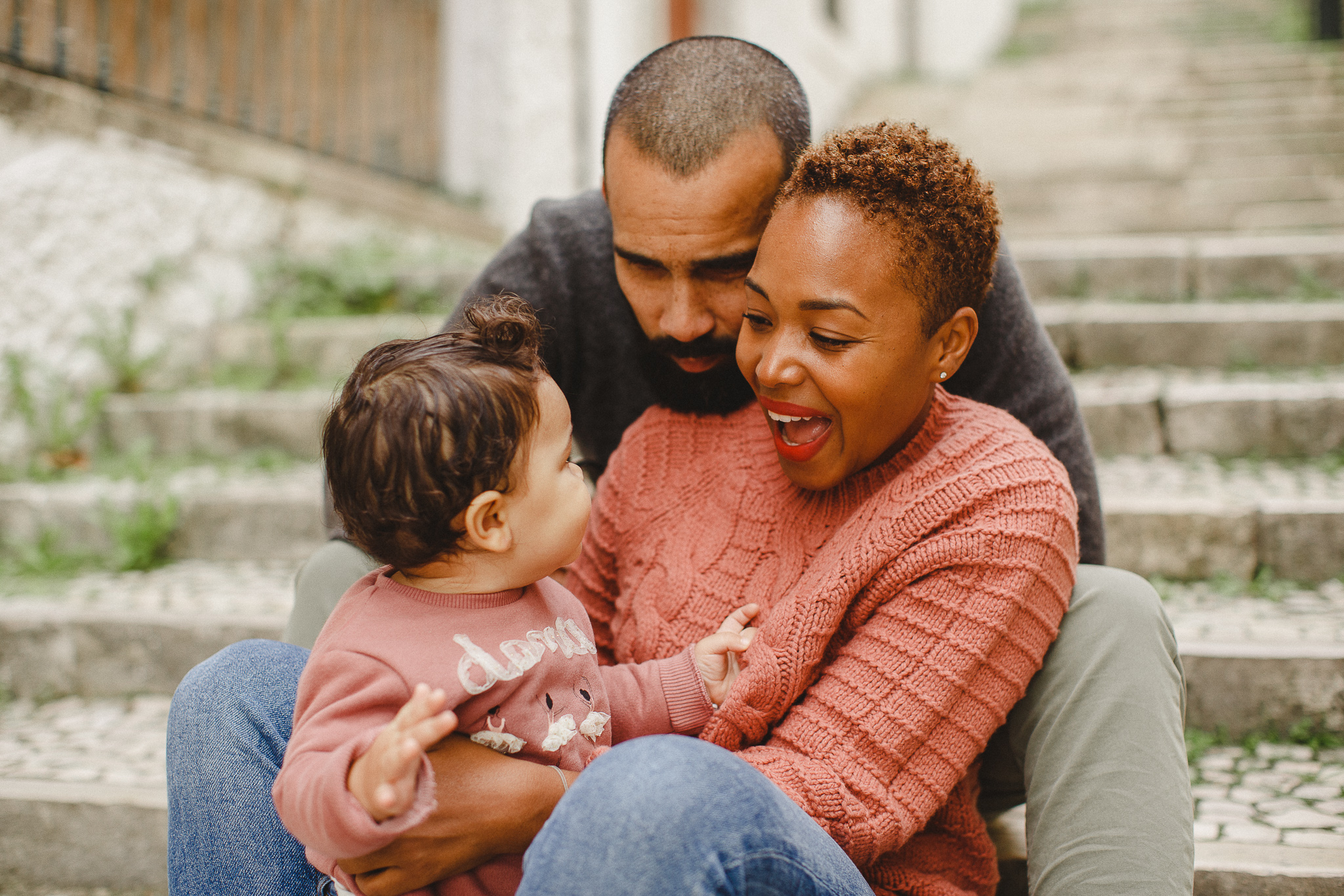 Parents smiling with baby during a family photo shoot in Lisbon. 