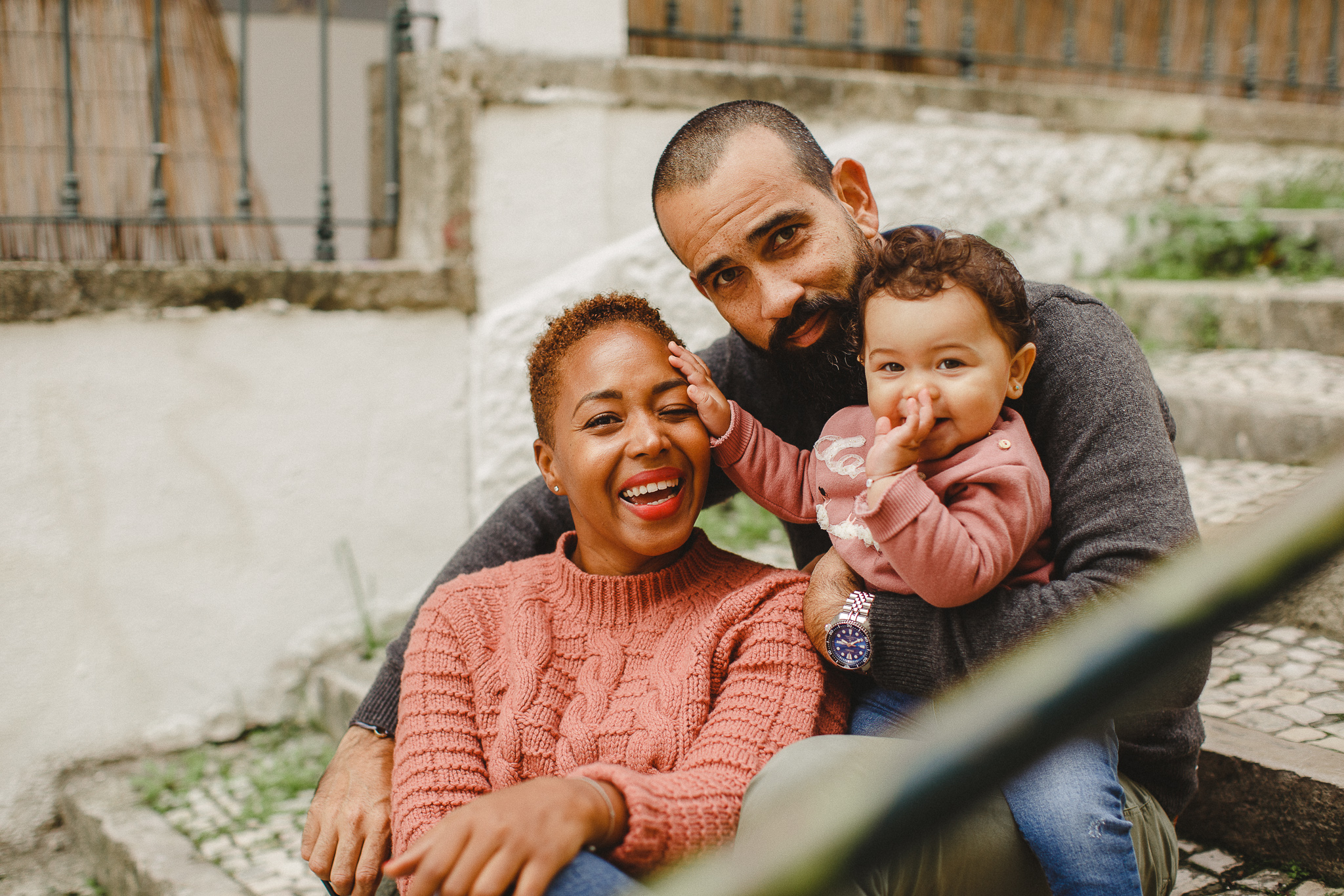 Parents smiling with baby during a family photo shoot in Lisbon. 